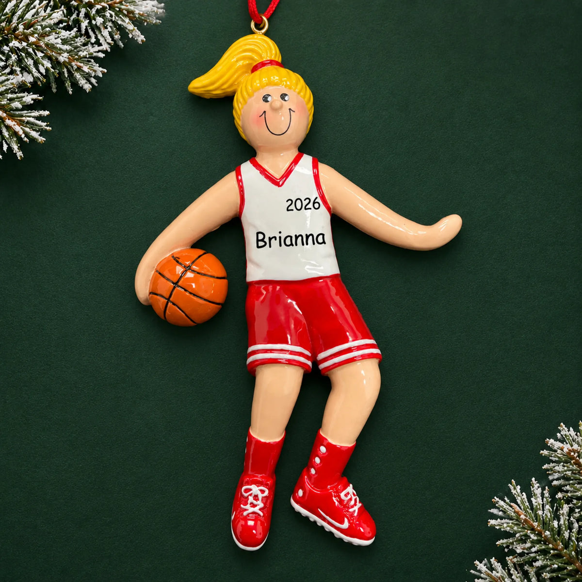 Personalized blonde basketball girl christmas ornament on a dark green pine background