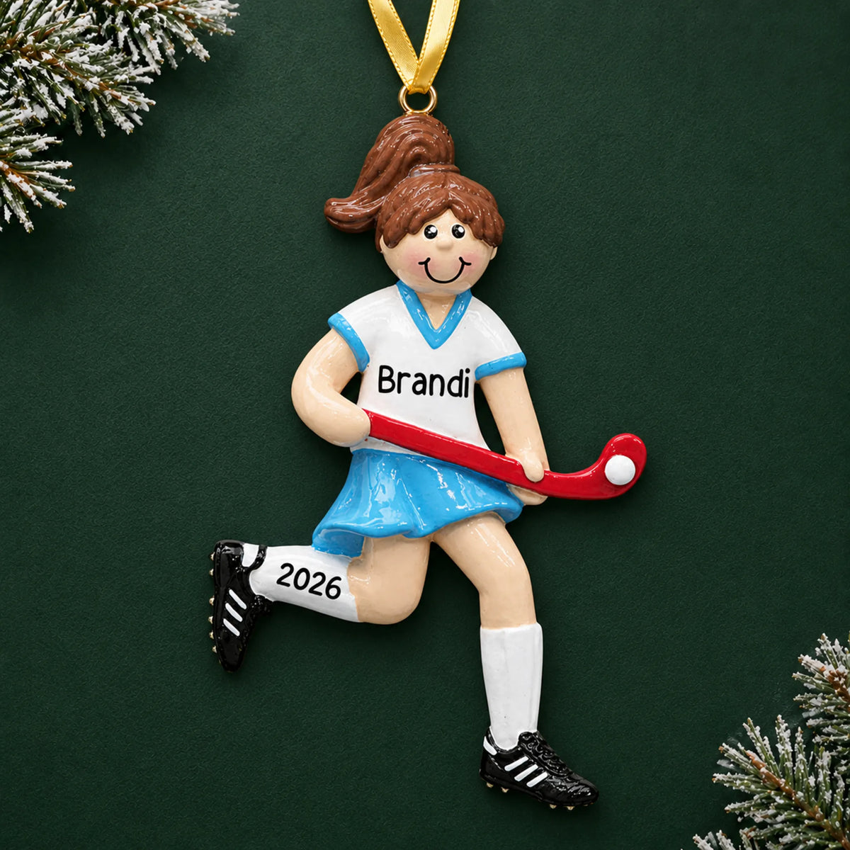 Personalized field hockey girl christmas ornament on a dark green pine background