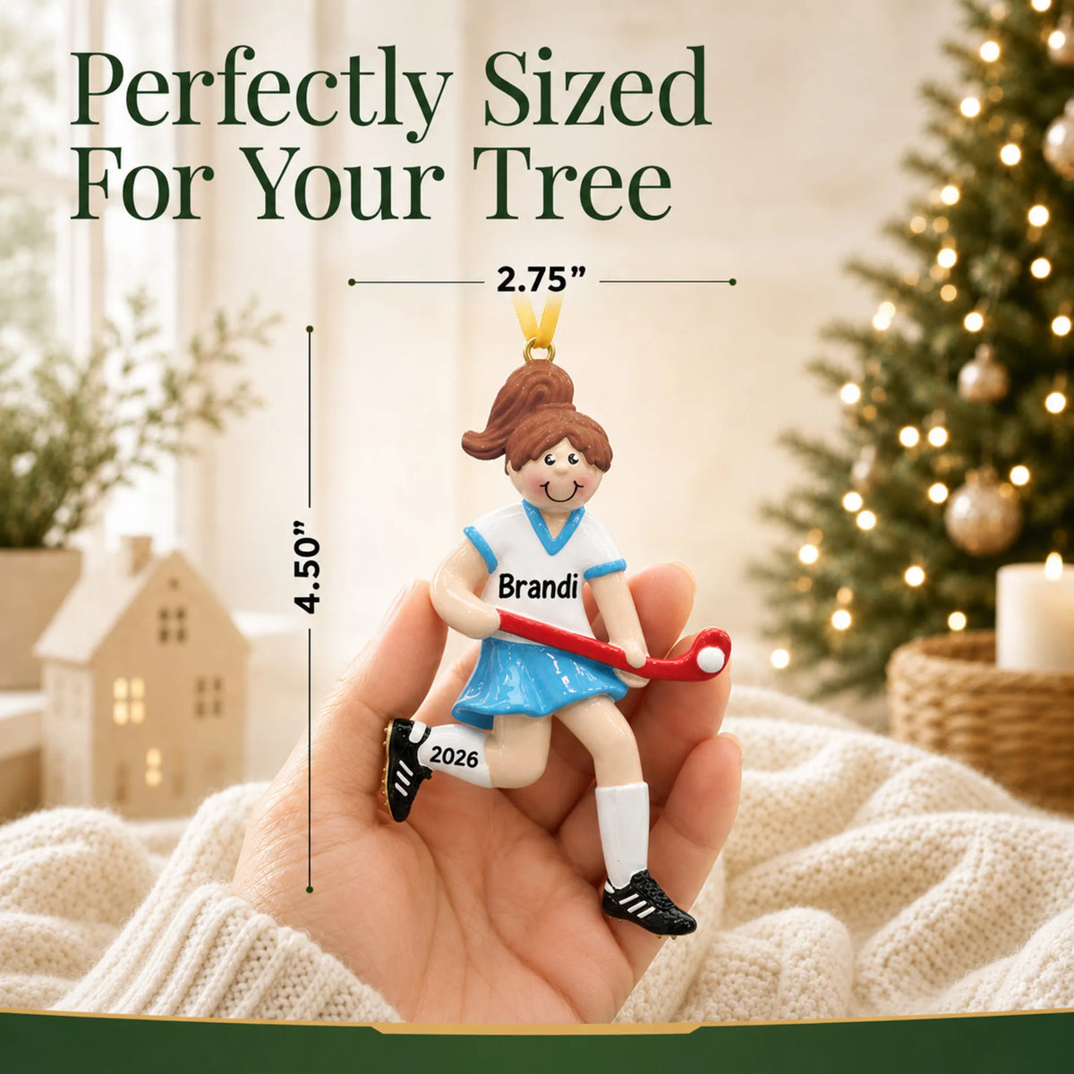 Size guide: the personalized field hockey girl christmas ornament is 2.75 in wide by 4.50 in tall, shown in hand