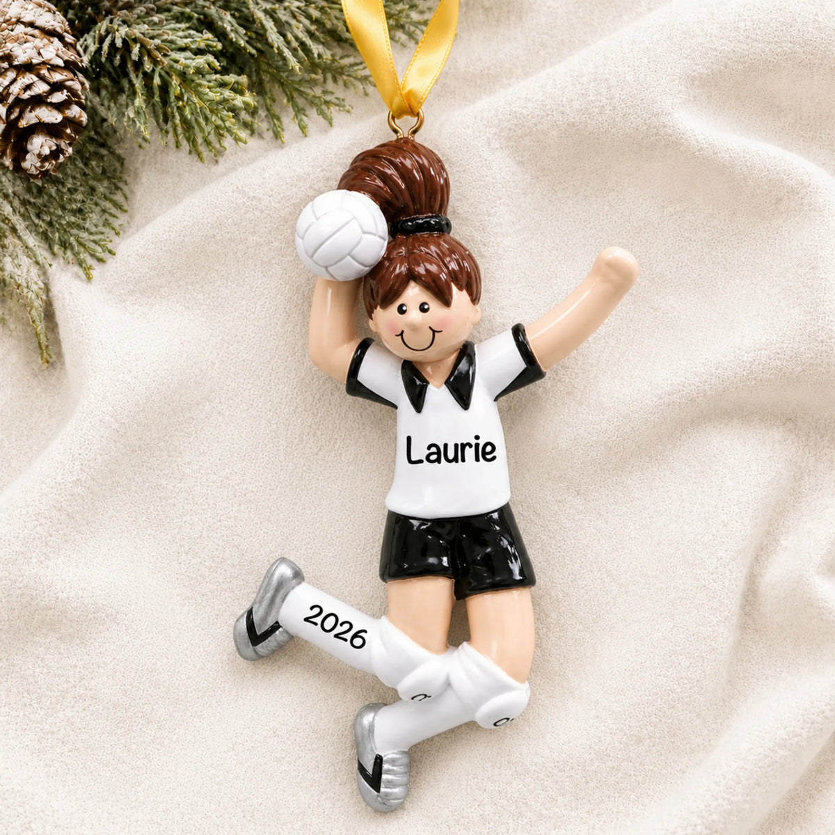 Personalized volleyball girl christmas ornament laid on a soft white knit blanket