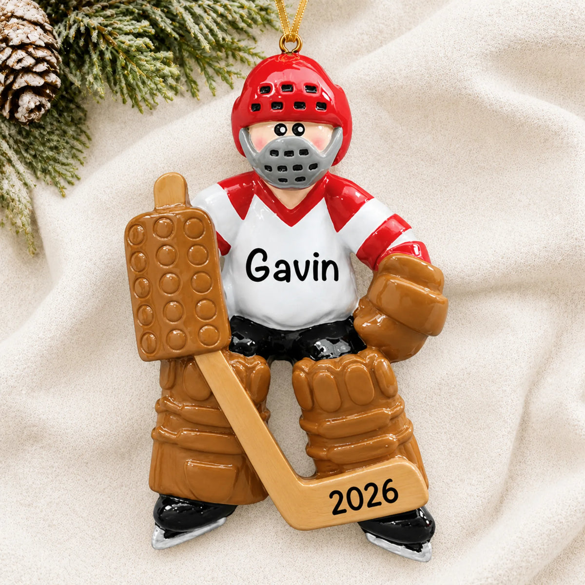 Personalized ice hockey goalie christmas ornament laid on a soft white knit blanket