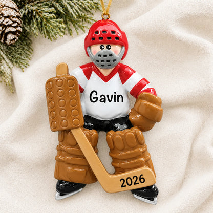 Personalized ice hockey goalie christmas ornament laid on a soft white knit blanket