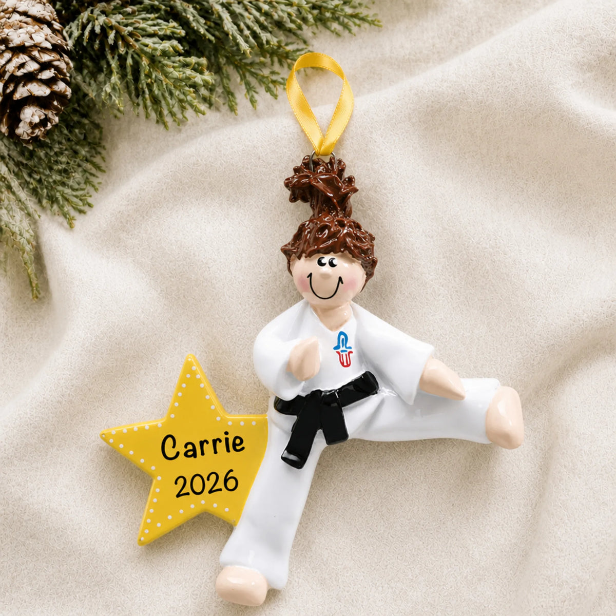 Personalized karate girl christmas ornament laid on a soft white knit blanket
