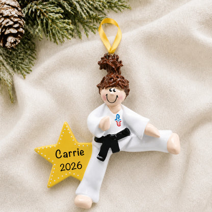 Personalized karate girl christmas ornament laid on a soft white knit blanket