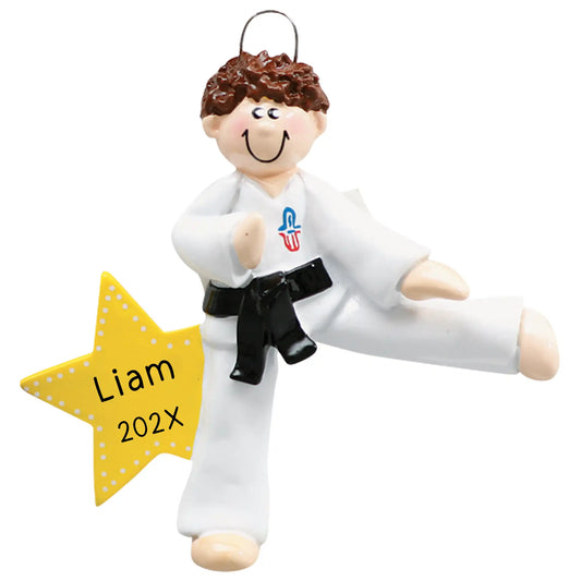 A personalized ornament featuring a cartoon-style martial arts instructor in a white uniform with a black belt, posed in a power stance, with a yellow star banner that reads 'Liam 202x'.