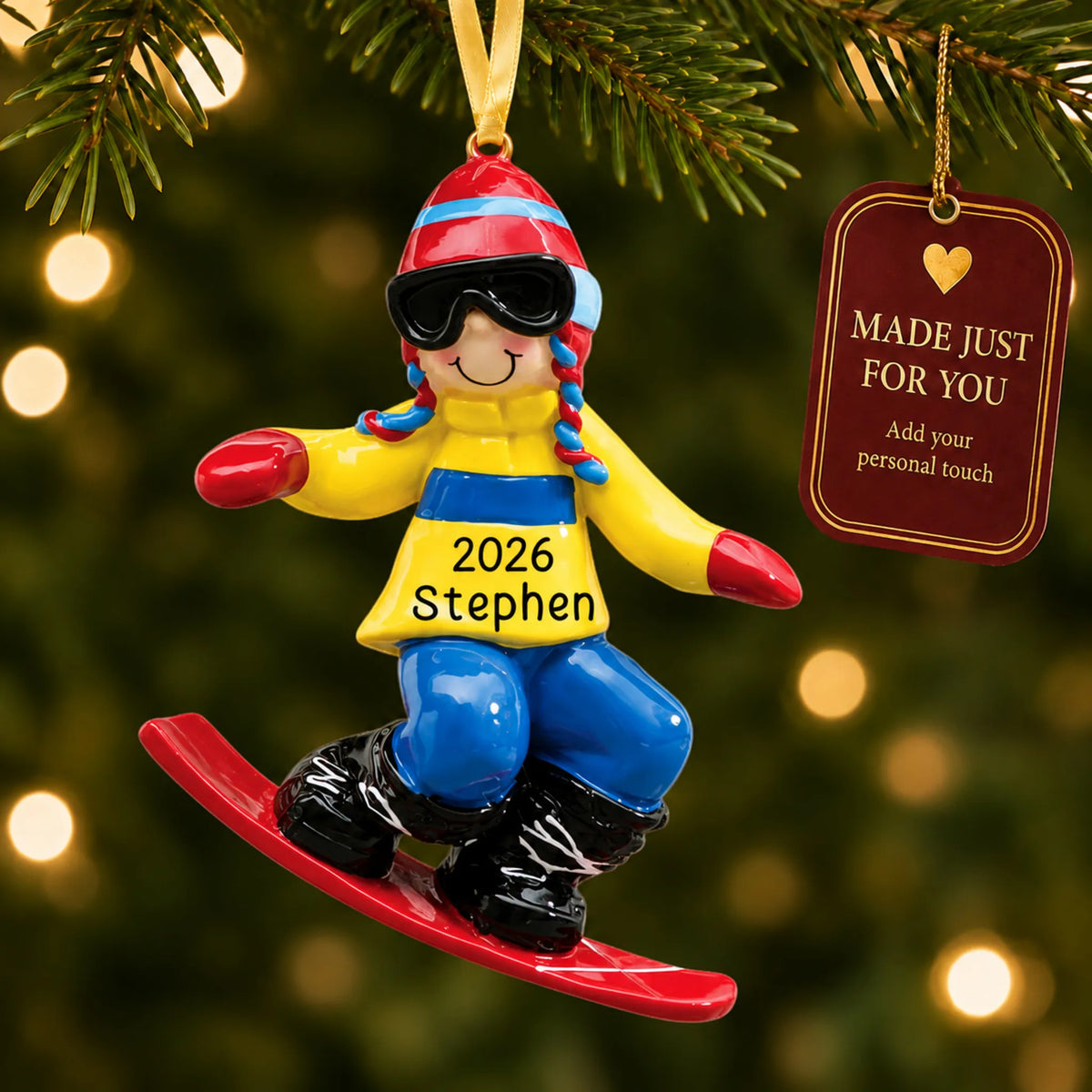 Snowboard guy christmas ornament hanging on a lit Christmas tree with a Made Just For You gift tag