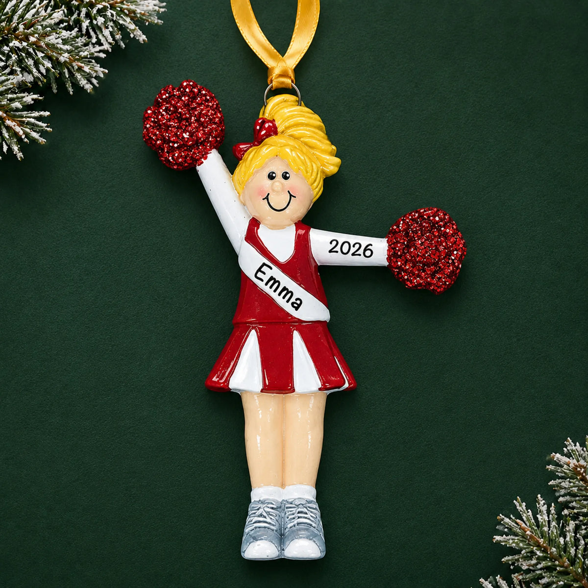 Personalized blonde pom pom cheerleader christmas ornament on a dark green pine background