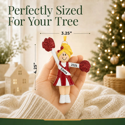 Size guide: the personalized blonde pom pom cheerleader christmas ornament shown in hand next to a Christmas tree