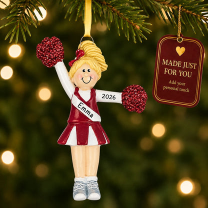 Blonde pom pom cheerleader christmas ornament hanging on a lit Christmas tree with a Made Just For You gift tag