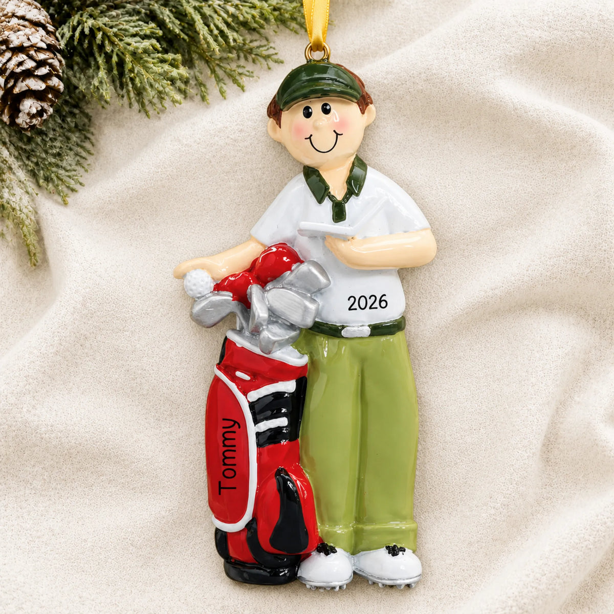 Personalized golfer christmas ornament laid on a soft white knit blanket