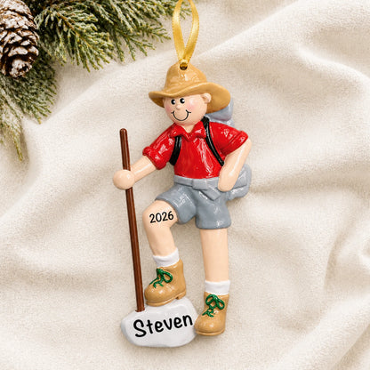 Personalized Hiker christmas ornament laid on a soft white knit blanket