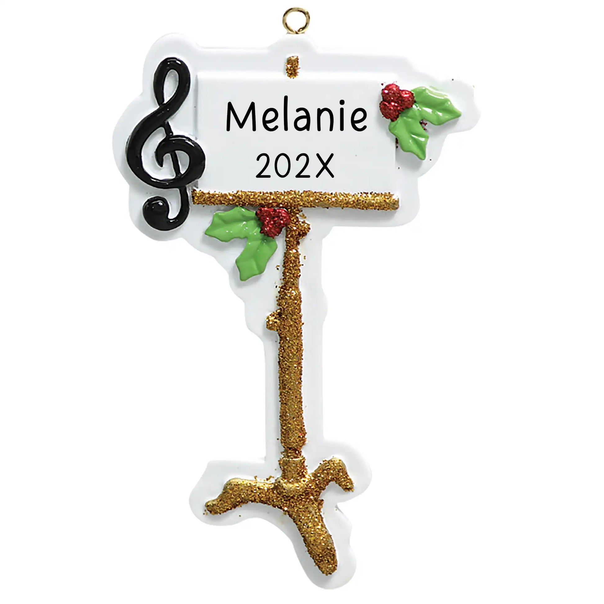 A Christmas ornament featuring a music stand with musical notes, a sheet of music, and holly leaves. The ornament is white with glitter and has 'Stephanie Year' printed on it.