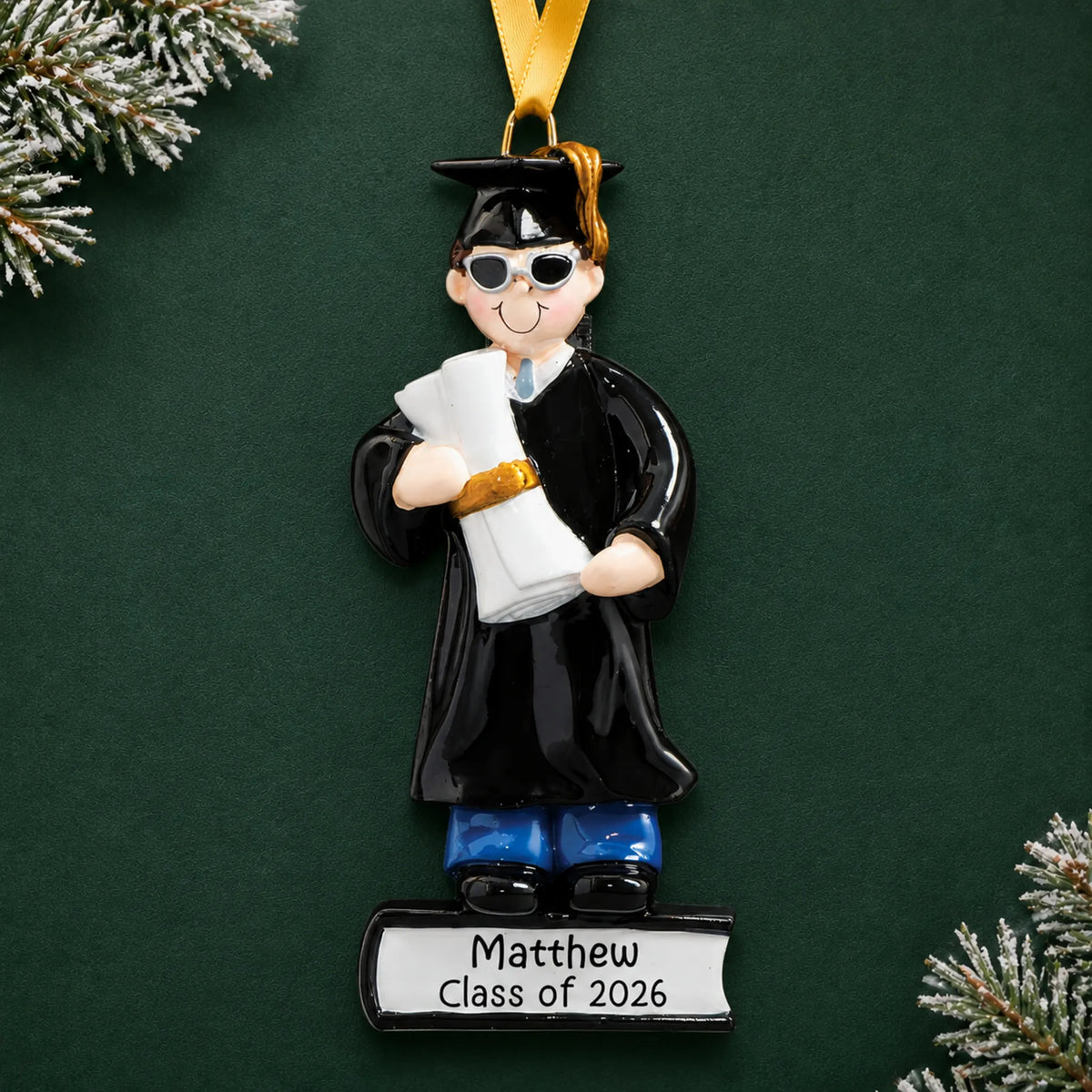 Personalized graduation guy Christmas ornament in cap and gown with sunglasses, holding a diploma, name and class year engraved on the base