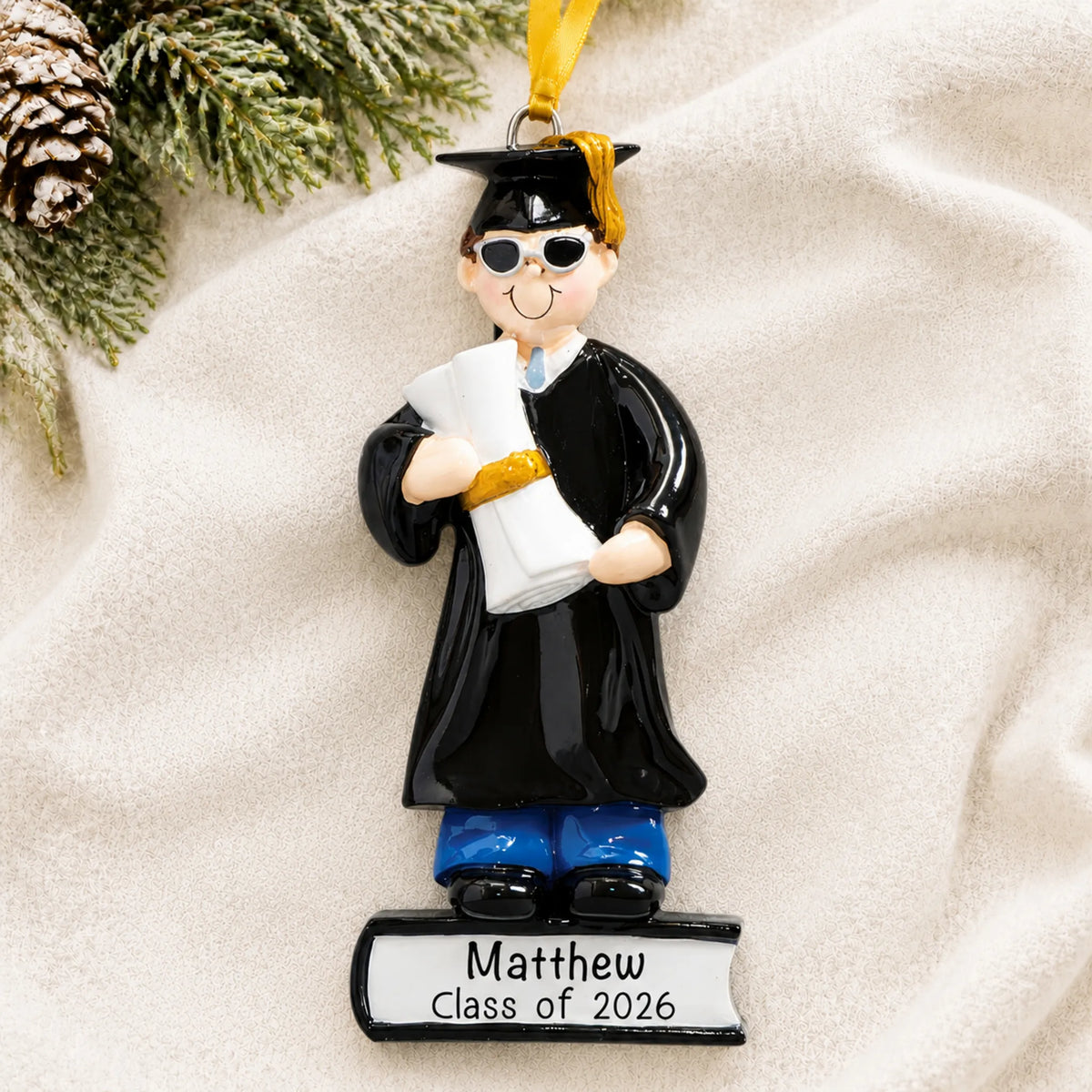 Front view of the personalized graduation guy Christmas ornament in cap and gown with sunglasses, holding a diploma