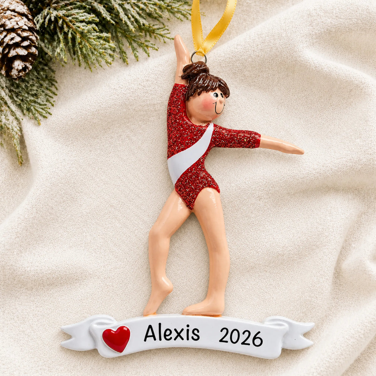Personalized red leotard gymnast christmas ornament laid on a soft white knit blanket