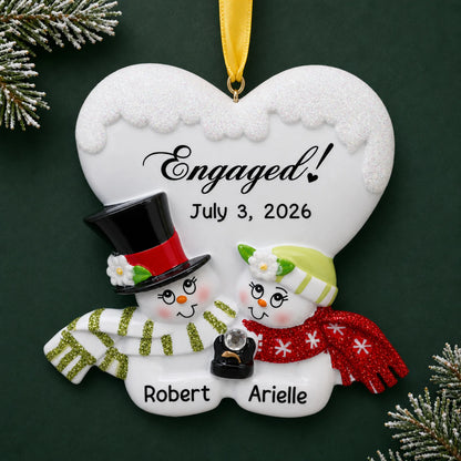 Personalized engaged snow couple Christmas ornament with two snowmen under an Engaged! heart with names and date
