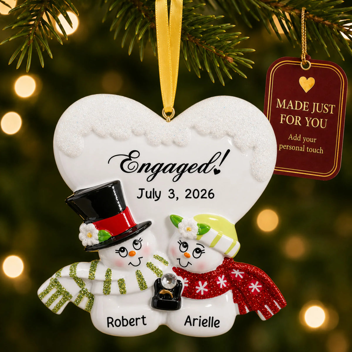 Personalized engaged snow couple Christmas ornament on a lit Christmas tree with a Made Just For You tag