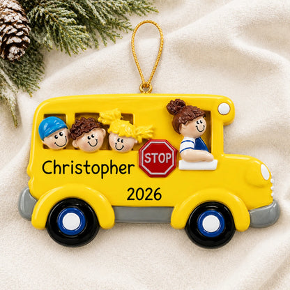 Personalized Kids School Bus christmas ornament laid on a soft white knit blanket