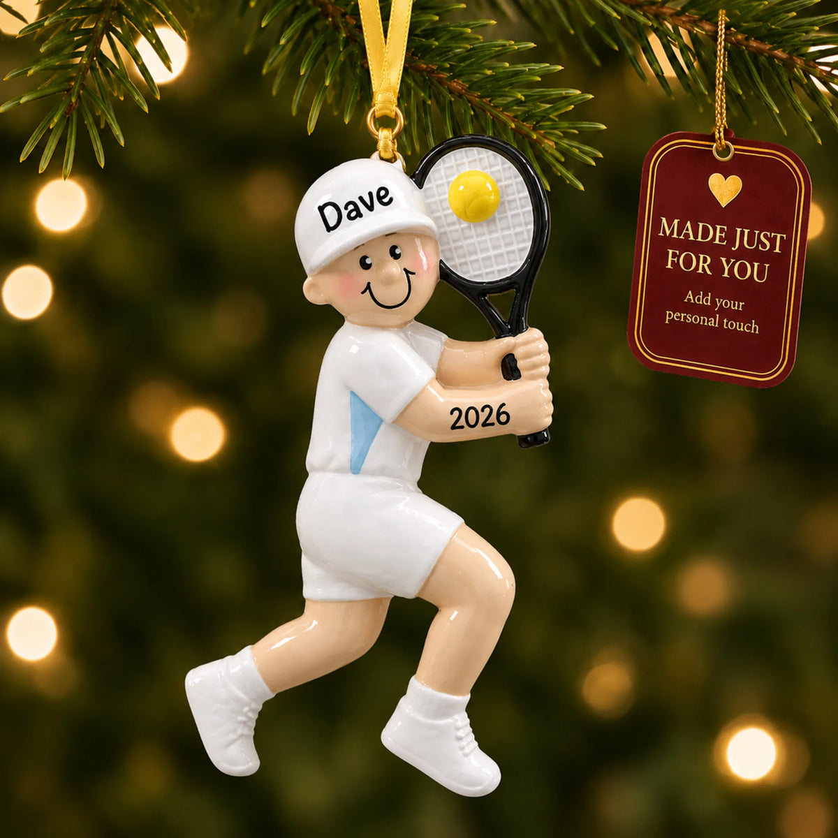 Tennis guy christmas ornament hanging on a lit Christmas tree with a Made Just For You gift tag