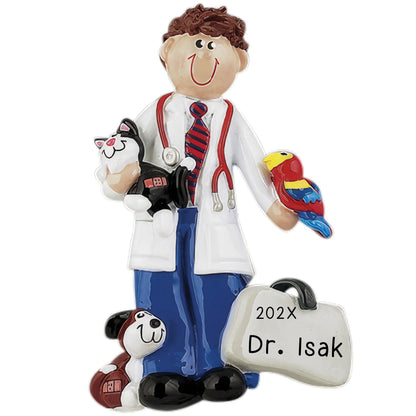A personalized holiday ornament featuring a cartoon-style veterinarian character with a stethoscope, holding a teddy bear and a tag with '202x Dr. Isak' on it.