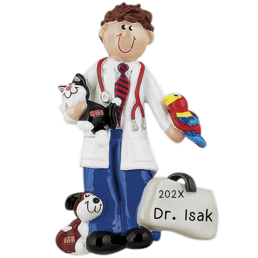A personalized holiday ornament featuring a cartoon-style veterinarian character with a stethoscope, holding a teddy bear and a tag with '202x Dr. Isak' on it.