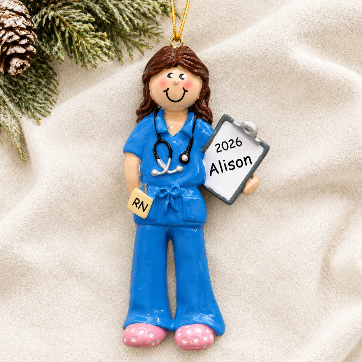 Personalized nurse christmas ornament laid on a soft white knit blanket