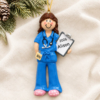 Personalized nurse christmas ornament laid on a soft white knit blanket