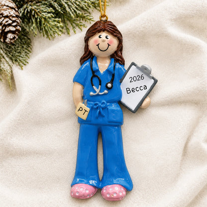 Personalized physical therapist christmas ornament laid on a soft white knit blanket