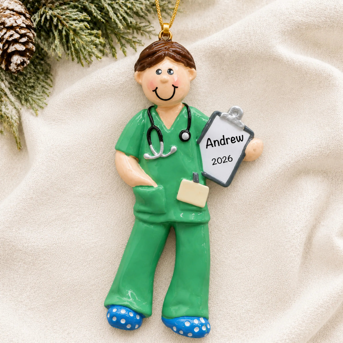 Personalized scrubs medical professional christmas ornament laid on a soft white knit blanket