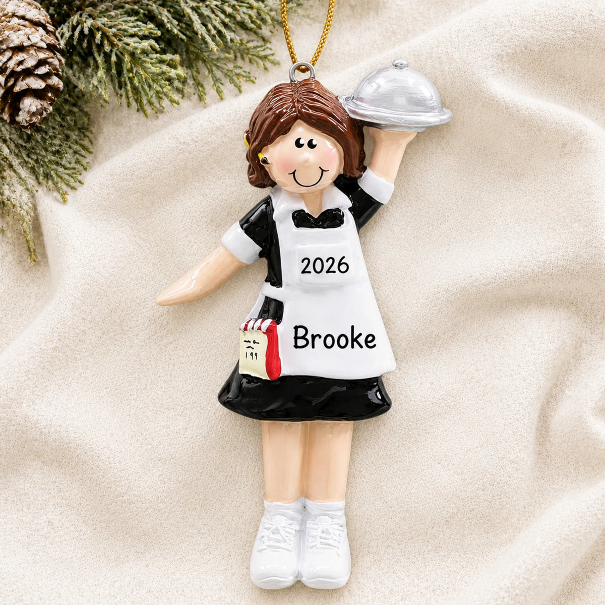 Personalized waitress server christmas ornament laid on a soft white knit blanket
