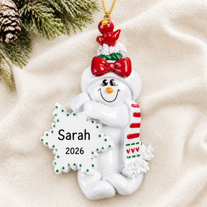 Personalized Birdsnest Snow Woman christmas ornament laid on a soft white knit blanket