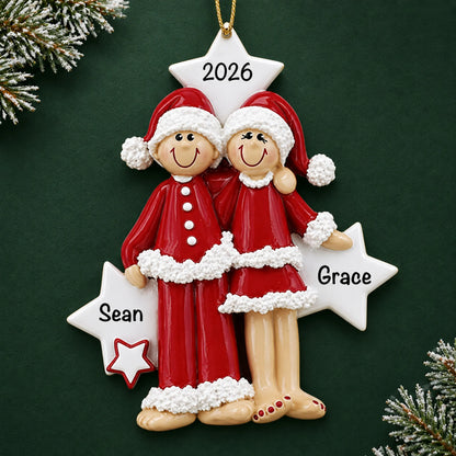 Personalized christmas pajama couple ornament on a dark green pine background