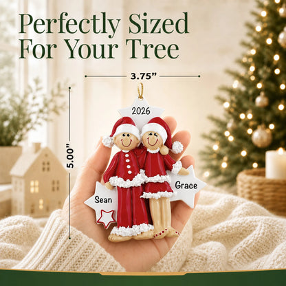 Size guide: the personalized christmas pajama couple ornament is 3.75 in wide by 5.00 in tall, shown in hand
