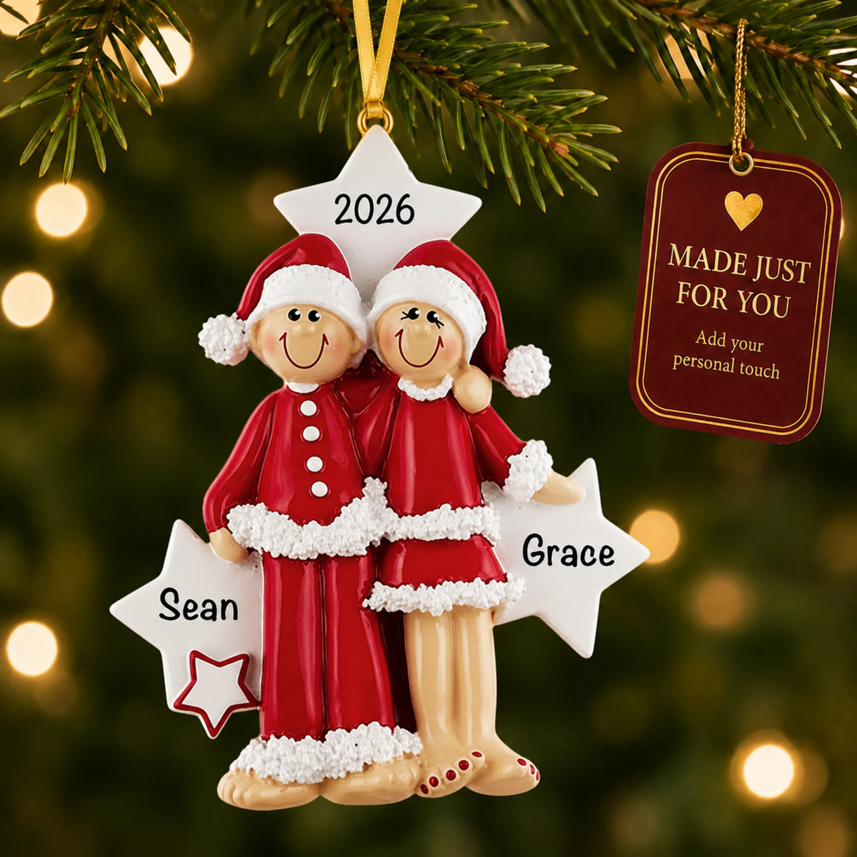 Christmas pajama couple ornament hanging on a lit Christmas tree with a Made Just For You gift tag
