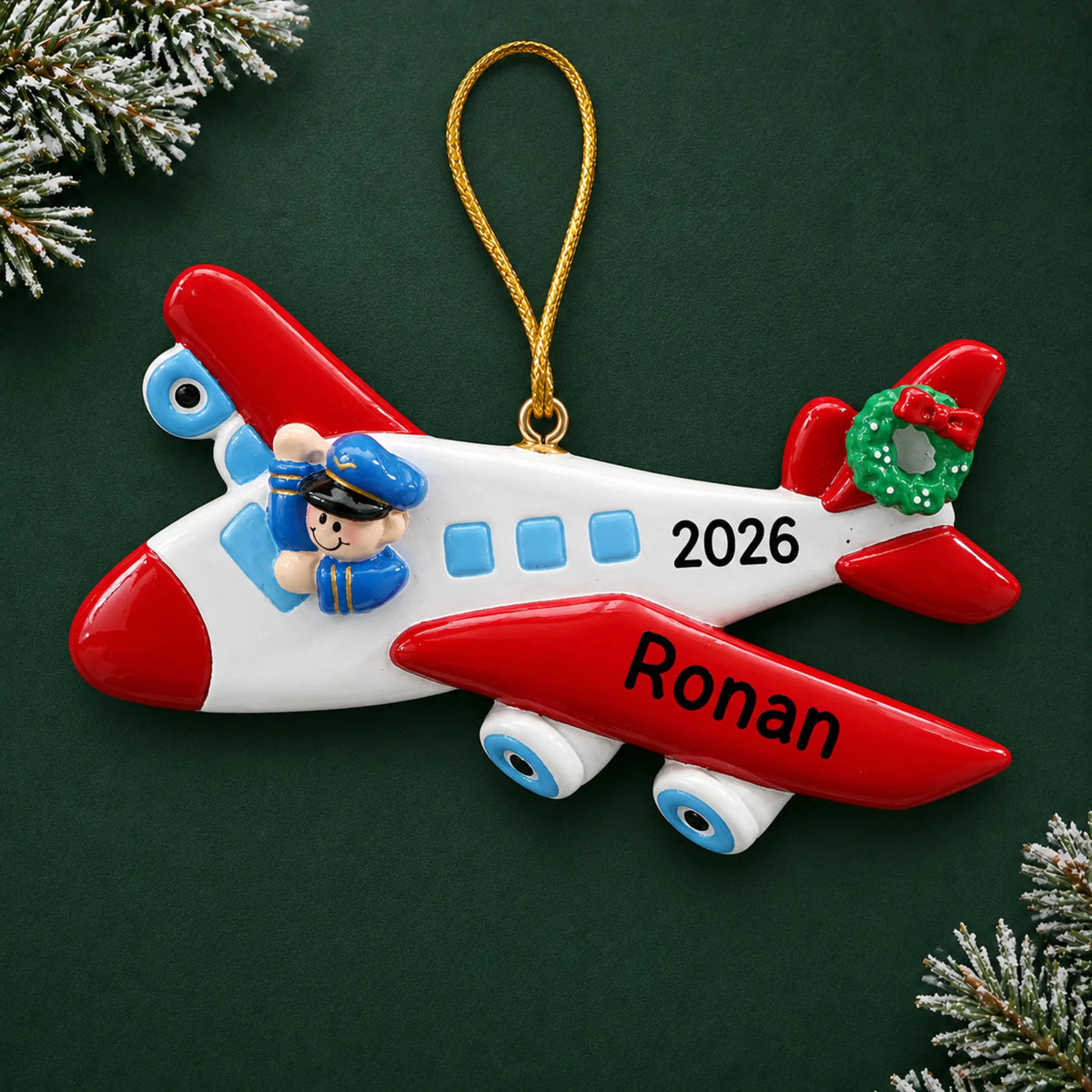Personalized airplane pilot christmas ornament on a dark green pine background
