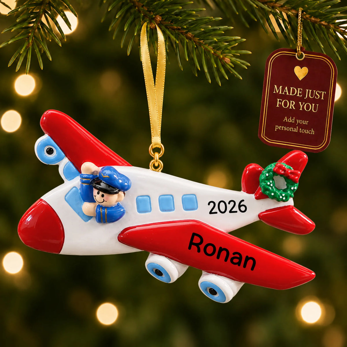 Airplane pilot christmas ornament hanging on a lit Christmas tree with a Made Just For You gift tag