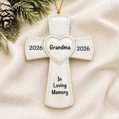 Personalized White Cross Memorial christmas ornament laid on a soft white knit blanket