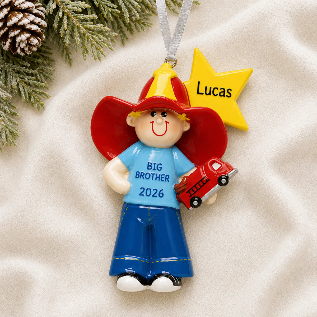 Personalized big brother firefighter christmas ornament laid on a soft white knit blanket