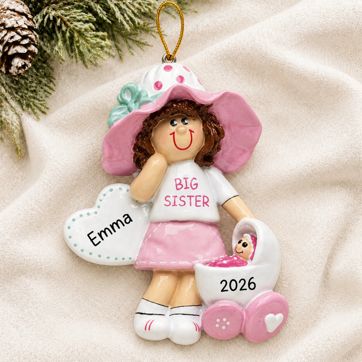 Personalized brunette big sister christmas ornament laid on a soft white knit blanket