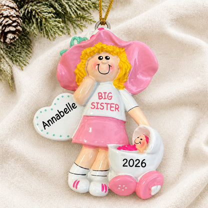 Personalized blonde big sister christmas ornament laid on a soft white knit blanket