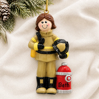 Personalized firefighter woman christmas ornament laid on a soft white knit blanket