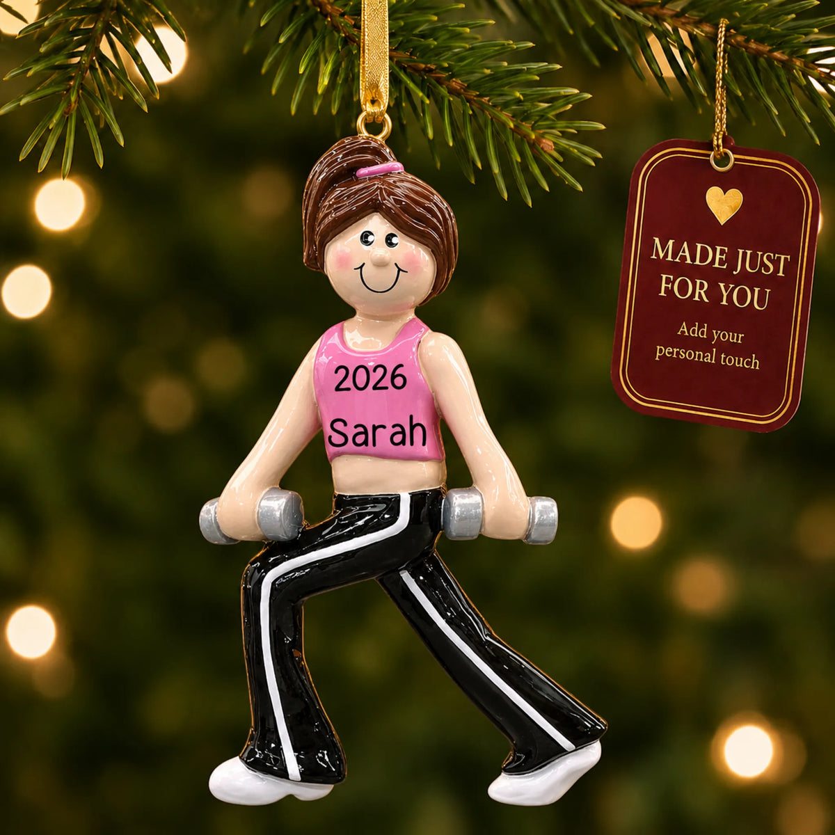Female fitness christmas ornament hanging on a lit Christmas tree with a Made Just For You gift tag