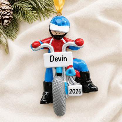 Personalized dirt bike rider christmas ornament laid on a soft white knit blanket