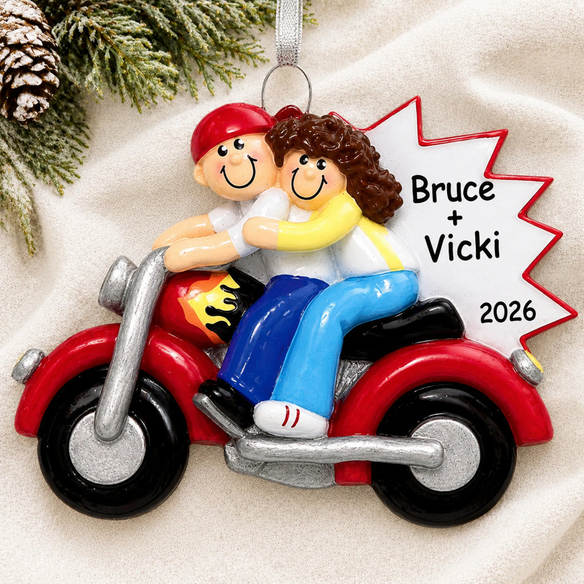 Personalized motorcycle couple christmas ornament laid on a soft white knit blanket