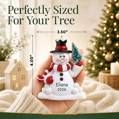 Size guide: the personalized Snowman with Tree christmas ornament is 3.50 in wide by 4.00 in tall, shown in hand