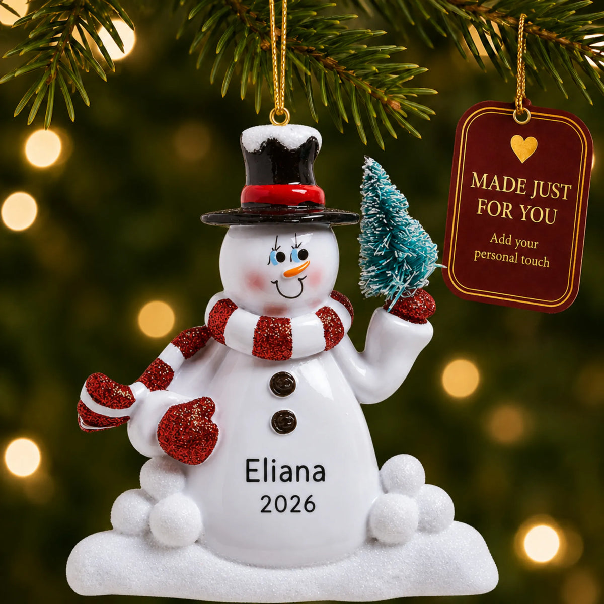 Snowman with Tree christmas ornament hanging on a lit Christmas tree with a Made Just For You gift tag