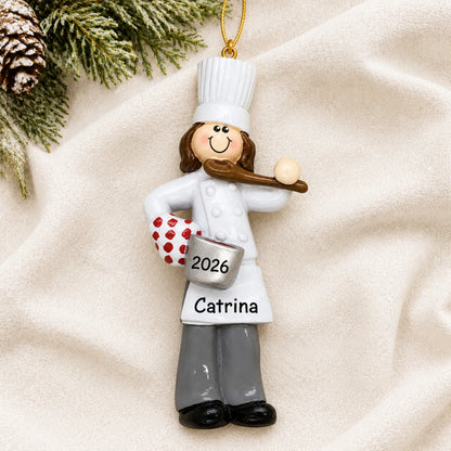 Personalized chef girl christmas ornament laid on a soft white knit blanket