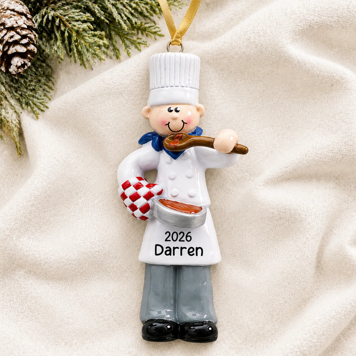 Personalized chef guy christmas ornament laid on a soft white knit blanket