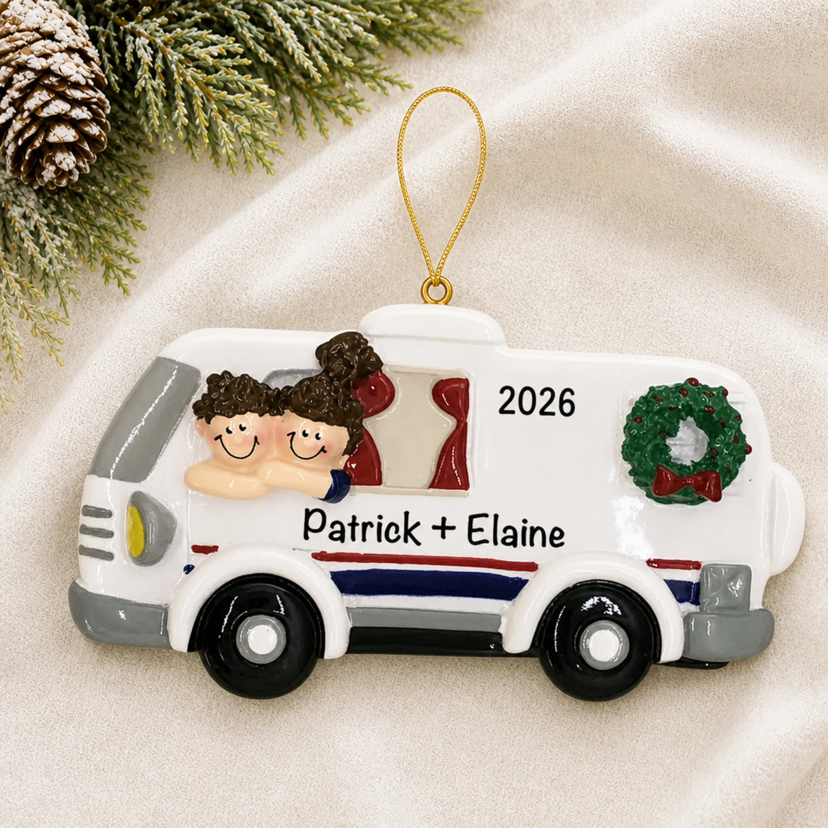 Personalized RV camping couple christmas ornament laid on a soft white knit blanket