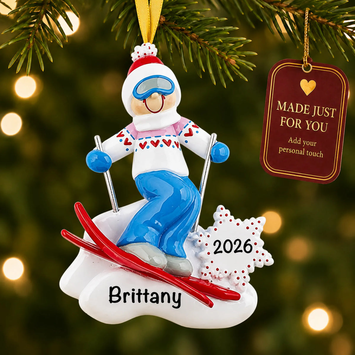 Ski girl christmas ornament hanging on a lit Christmas tree with a Made Just For You gift tag